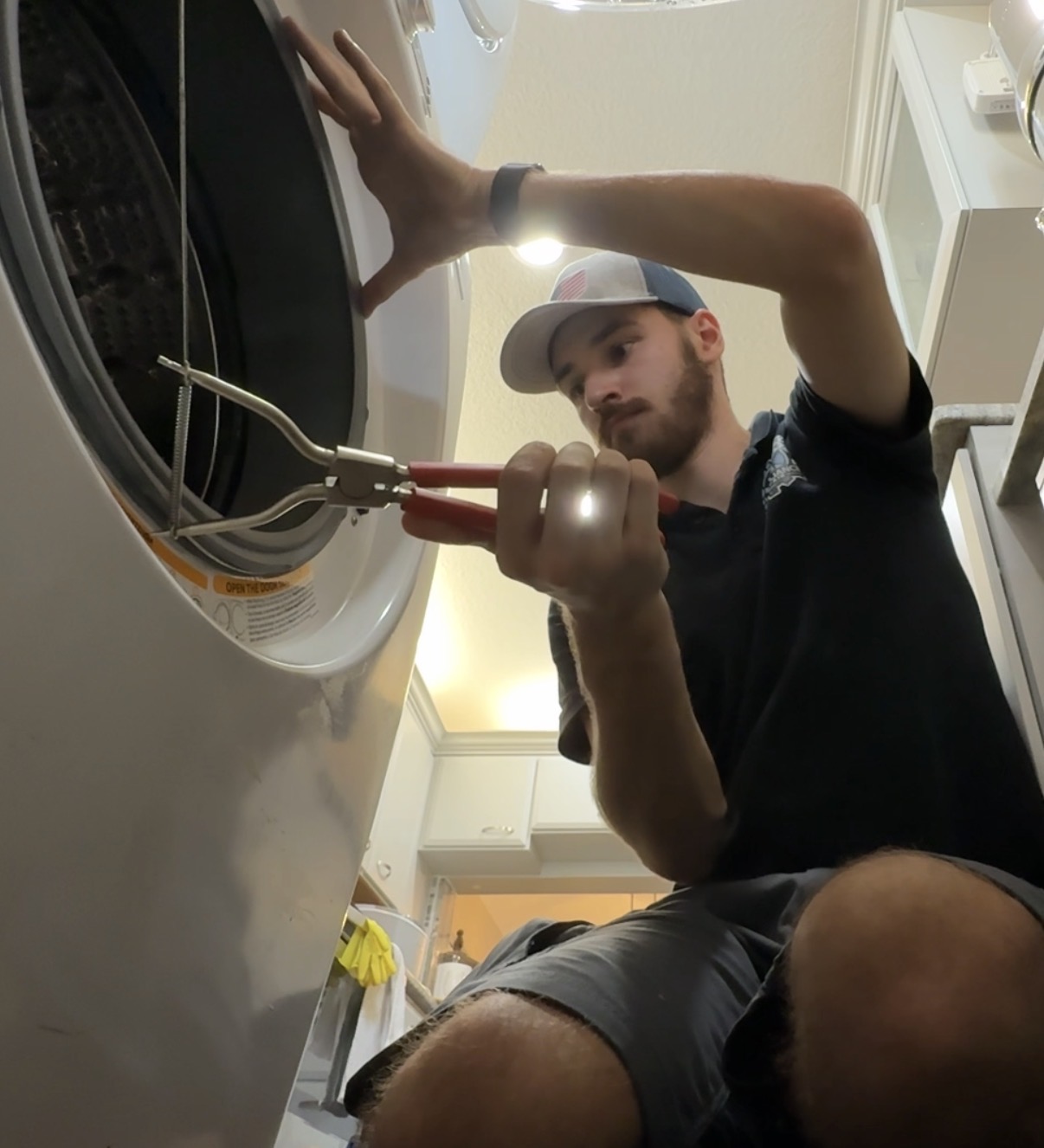 Pliers beside a washing-machine door gasket